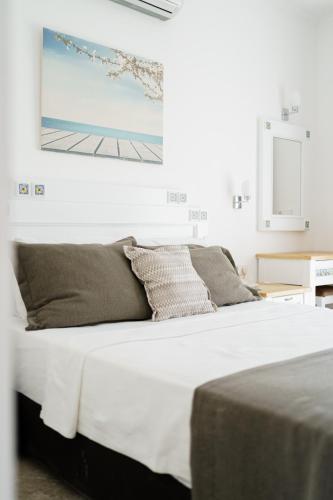 a bedroom with a bed with white sheets and a painting on the wall at Costa Sariyaz Hotel Bodrum in Bodrum City