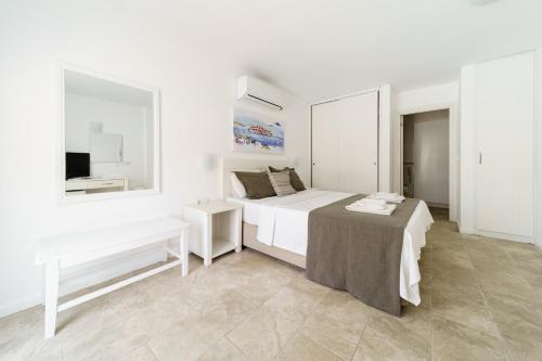 a white bedroom with a bed and a tv at Costa Sariyaz Hotel Bodrum in Bodrum City
