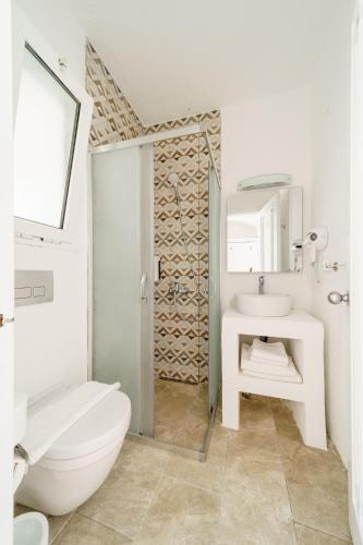 a white bathroom with a sink and a toilet at Costa Sariyaz Hotel Bodrum in Bodrum City