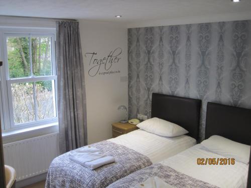 a bedroom with two beds and a window at Glenburn Guest House in Windermere