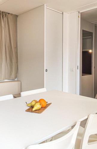 a white table with a plate of fruit on it at La Pineta in Albenga