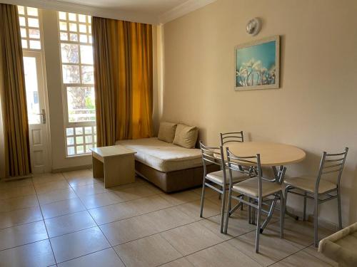 uma sala de estar com uma mesa e cadeiras e um sofá em İSABELLA APART OTEL em Alanya