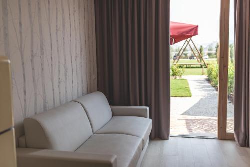 a living room with a white couch and a sliding glass door at Antico Podere San Francesco in Vada