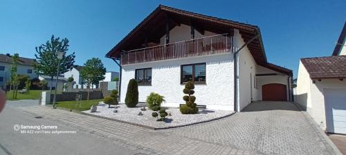a white house with a balcony and a driveway at Appartement Köck 110qm in Reisbach