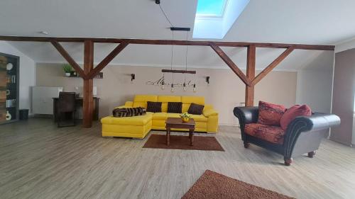 salon z żółtą kanapą i 2 krzesłami w obiekcie Appartement Köck 110qm w mieście Reisbach