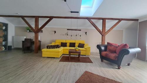 a living room with a yellow couch and two chairs at Appartement Köck 110qm in Reisbach