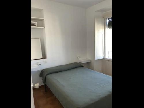 a small bedroom with a bed and a window at Apartamento luminoso y acogedor Port de la Selva in Port de la Selva