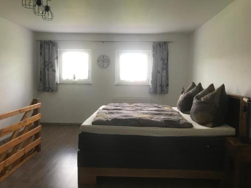 a bedroom with a large bed with two windows at Apartment Sioux in Eging