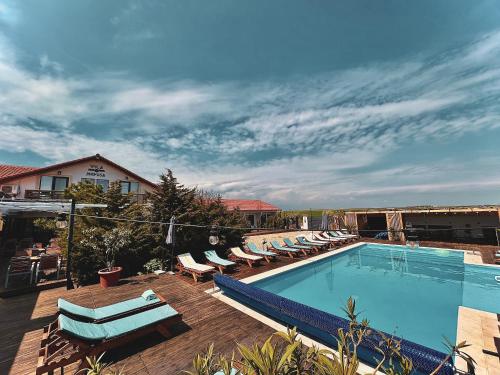 a large swimming pool with lounge chairs at Vila Medusa in Vama Veche