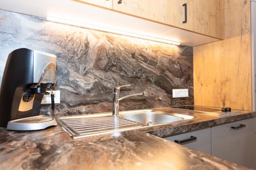 a kitchen counter with a sink and a coffee maker at Haus Bergliebe in Maria Alm am Steinernen Meer