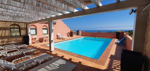 a swimming pool on top of a house at Villa Cabanas beach in Budens