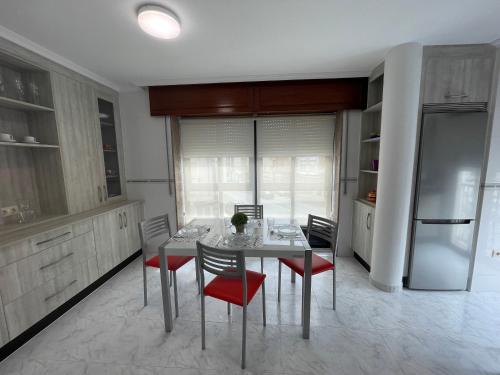 Il comprend une cuisine équipée d'une table, de chaises et d'un réfrigérateur. dans l'établissement Alojamiento Apostol 1, à Melide