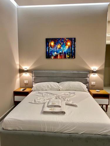 a bedroom with a bed with a painting on the wall at Hotel Real in Ishull-Lezhë