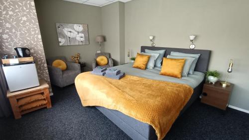 a bedroom with a large bed and a television at Hotel Rozenburg in Rozenburg