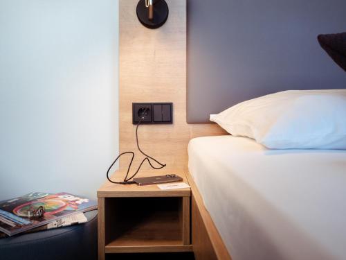 a bedroom with a bed and a lamp at aletto Hotel Potsdamer Platz in Berlin