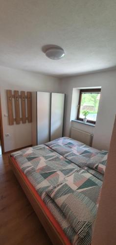 1 dormitorio con 1 cama en una habitación con ventana en Apartment Podkuze en Mojstrana