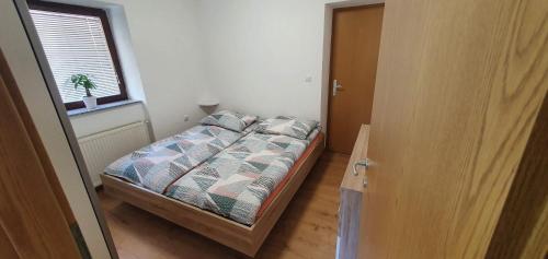 a small bedroom with a bed and a window at Apartment Podkuze in Mojstrana