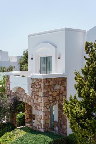 a white house with an archway in a yard at Costa Sariyaz Hotel Bodrum in Bodrum City