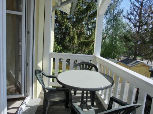 einen Tisch und Stühle auf einer Veranda mit einem Tisch in der Unterkunft Ferienwohnung T7 in Graal-Müritz