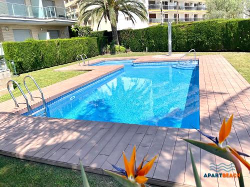 a swimming pool in a yard next to a building at APARTBEACH PANORAMIC VISTAS PLAYA y PISCINA in Miami Platja