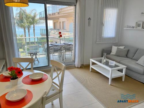 a living room with a couch and a table with chairs at APARTBEACH PANORAMIC VISTAS PLAYA y PISCINA in Miami Platja
