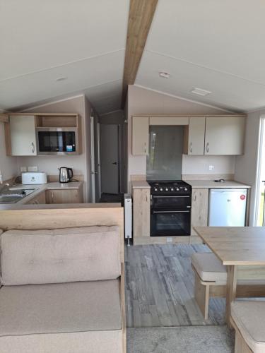 a kitchen with wooden cabinets and a table and a stove at Edwards Holiday Home in Blackpool