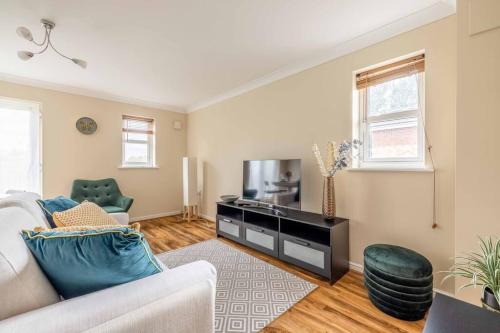 a living room with a couch and a tv at 2 BED 2 BATH with PARKING NEAR PINEWOOD, WEXHAM HOSPITAL - By Tempstay in Slough
