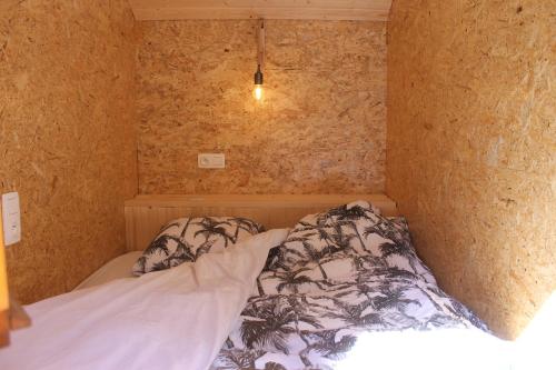 um pequeno quarto com uma cama no canto em La Roulotte Viticole - sauna - toilette sèche em Floreffe
