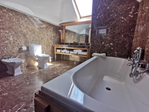 a bathroom with a bath tub and a toilet at Langtons Hotel Kilkenny in Kilkenny