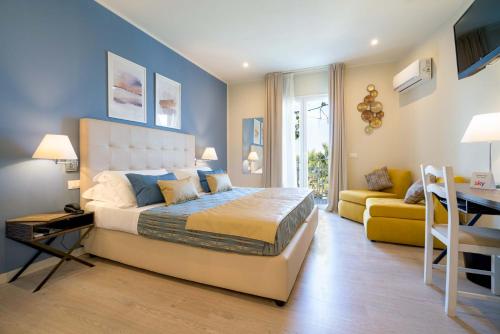 ein Schlafzimmer mit einem Bett, einem Tisch und einem Sofa in der Unterkunft Hotel Rivage Taormina in Taormina