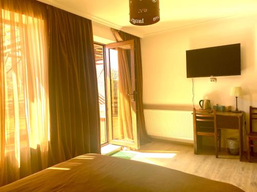 a bedroom with a bed and a large window at HOTEL KAZBEGI 1963 in Stepantsminda