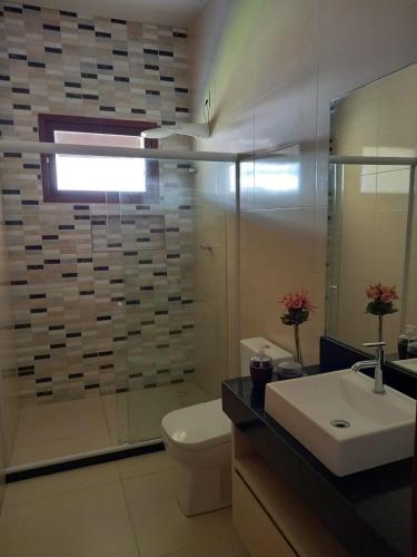 a bathroom with a sink and a toilet and a shower at Uma Casa para o Descanso! in Camaçari