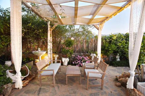 a patio with chairs and a pavilion with a table at Olympus Studios in Malia