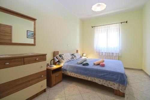 a bedroom with a bed and a dresser and a window at Apartments Veroslava 2159 in Pula