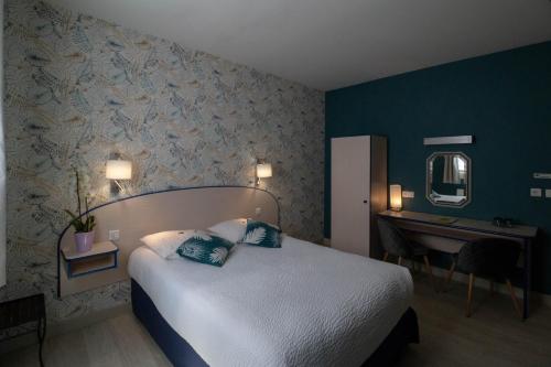 a bedroom with a bed and a desk and a mirror at LOGIS Le CANTAREL 