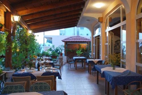 a restaurant with tables and chairs and a gazebo at Firenze Apartments in Ulcinj