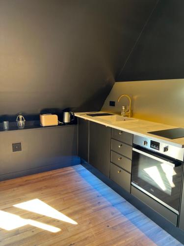 a kitchen with a sink and a stove at LA SUITE ISAHORA. Les Locations ISAHORA c'est aussi plusieurs appart' de Standing à 2 pas du Château d'Eu, des Falaises du Tréport, de MERS les Bains et Aux portes de la BAIE DE SOMME in Eu