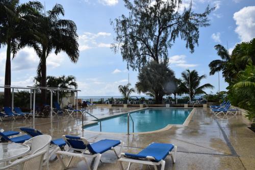 una piscina con sedie a sdraio e l'oceano di Goldenview a Saint James