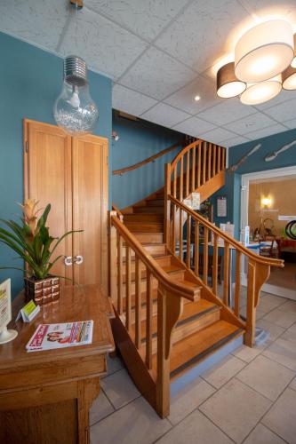 - un hall avec un escalier en bois et une table en bois dans l'établissement LOGIS Le CANTAREL, à Andelot