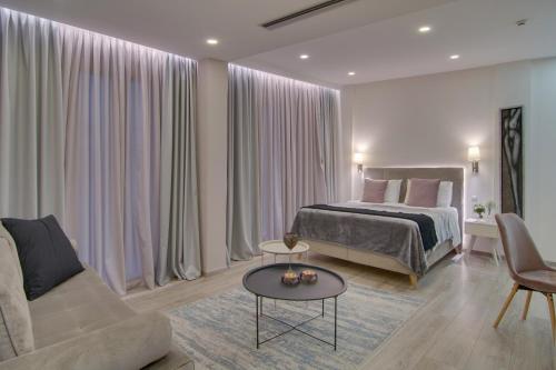 a bedroom with a bed and a couch and a table at ERMIS in Ioannina