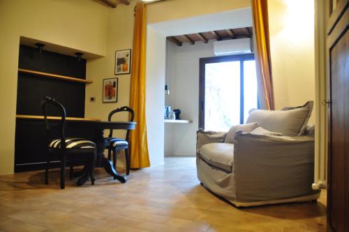 a living room with a table and a couch and a chair at suite la fortezza in Montalcino