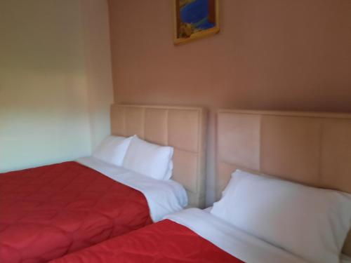 dos camas sentadas una al lado de la otra en una habitación en Sun& Relax Home, en Korçë