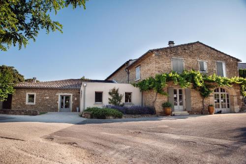 a brick house with a driveway in front of it at Domaine de Montine Chambres de Charme in Grignan