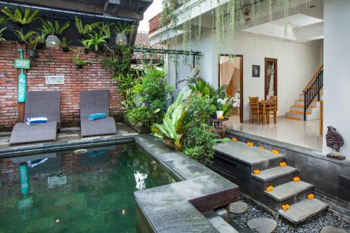 uma piscina numa casa com duas cadeiras e uma mesa em Ubudku Villas em Ubud