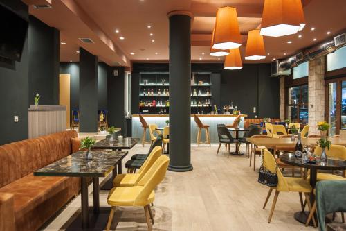 a restaurant with tables and chairs and a bar at Parnassos Delphi Hotel in Delfoi