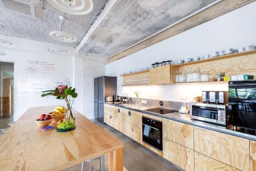 a large kitchen with wooden cabinets and a wooden table at Tech Spa Coliving&Coworking Spaces in Druskininkai