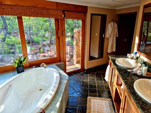 ein großes Badezimmer mit zwei Waschbecken und einer Badewanne in der Unterkunft Sekala Private Game Lodge in Welgevonden Game Reserve