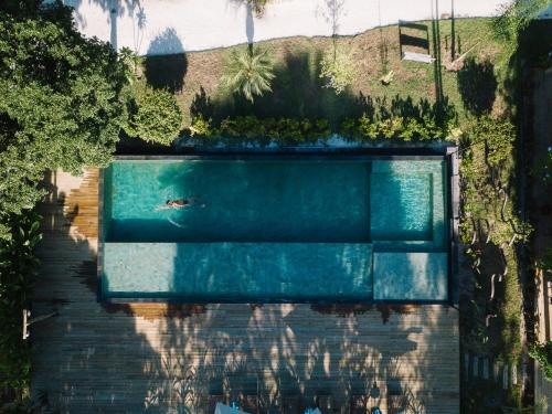 uma vista superior de uma piscina com uma pessoa a nadar em Villa dos Nativos Boutique Hotel em Trancoso