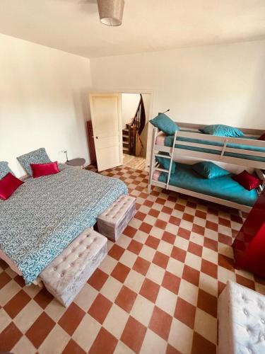 ein Schlafzimmer mit 2 Betten und einem karierten Boden in der Unterkunft Le bistrot de l'écluse in La Roussiere