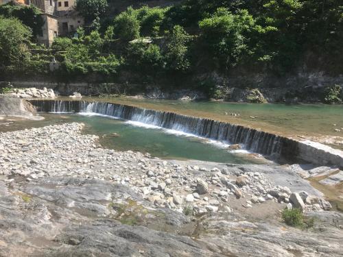 a small waterfall in a river with rocks at Alloggio U SPORTEGU DA E MONTI A GIAIA in Badalucco